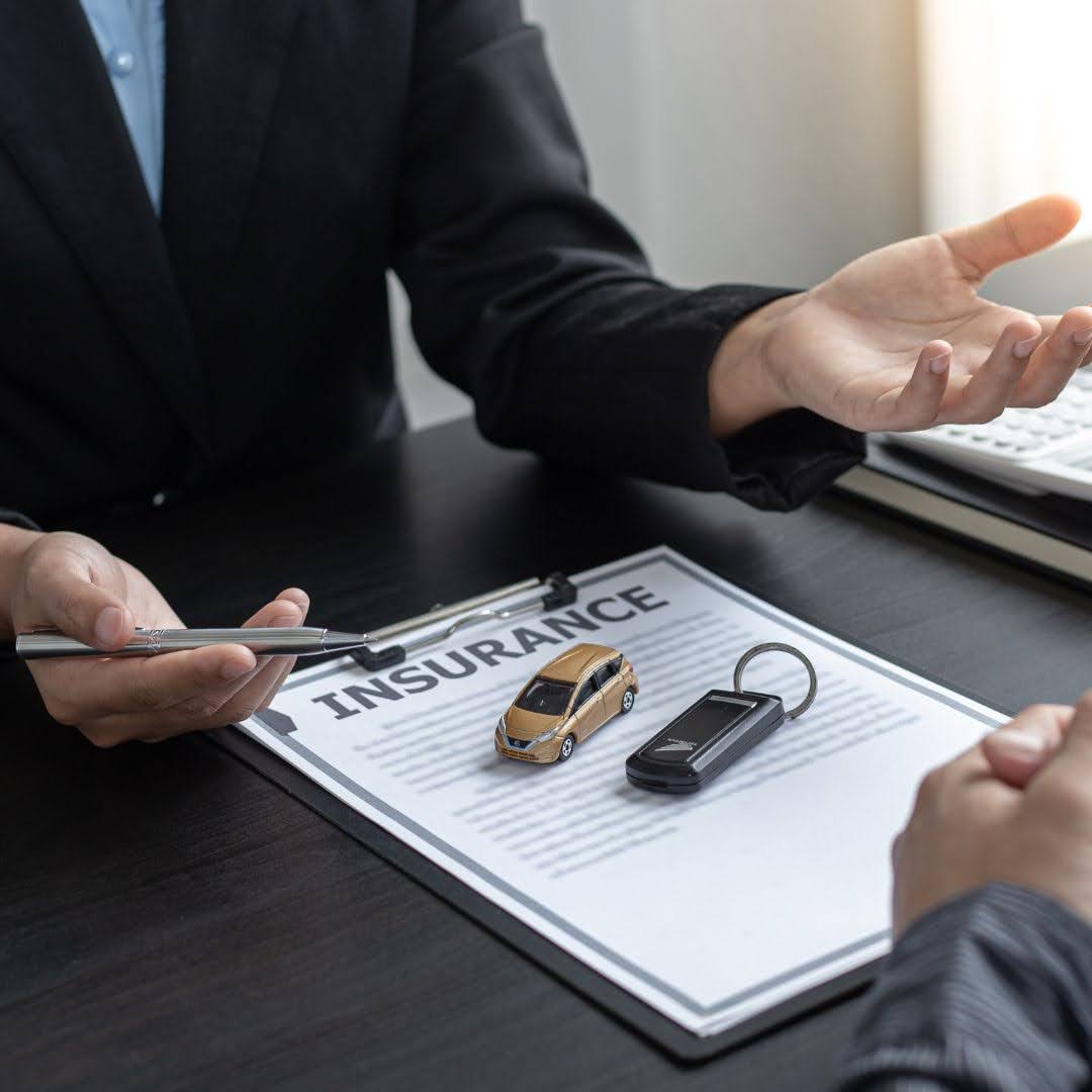 Car insurance agent showing policy details to a customer in 2025